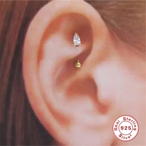 Macro view of S925 sterling silver curved barbell piercing with teardrop zircon on ear