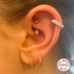 Close-up of S925 sterling silver earrings set with gold zircon and pink enamel hoops