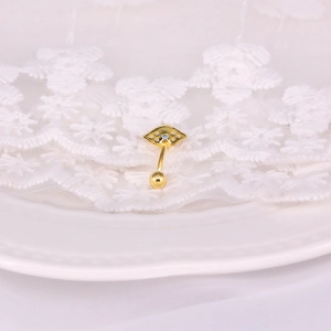 Macro view of gold S925 silver curved navel piercing ring with blue stone on lace fabric