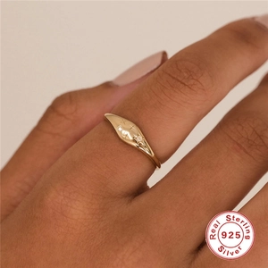 Detail eines S925 Sterlingsilber Goldrings mit Gravur und Zirkoniasteinen am Finger