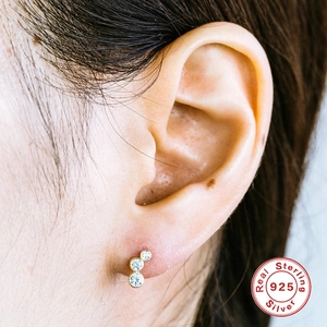 Nahaufnahme von drei runden Zirkonia in einem vergoldeten S925 Sterling Silber Piercing