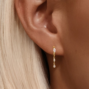 Close-up of S925 silver gold-plated hoop earring with marquise drop stones on ear