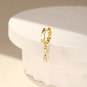 Macro detail of gold S925 silver huggie hoop earring with marquise zirconia charms