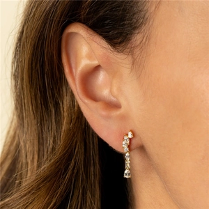 Detailed close-up of a gold s925 silver hoop earring with teardrop and star zircon stones