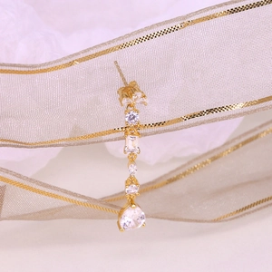 Close-up of golden S925 sterling silver long chain earrings with pear-cut cubic zirconia