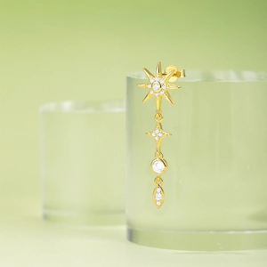Macro shot of 925 silver gold-plated celestial earring with marquise and star charms