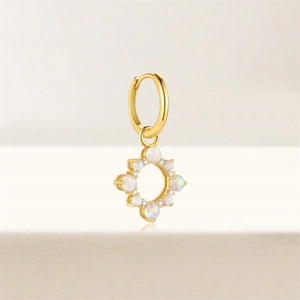 Macro detail of gold hoop earring with opal stone circle pendant and white crystals