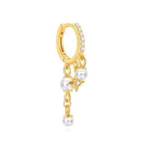 Detail of gold hoop earring featuring white pearls and a sparkling star pendant
