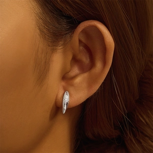 Macro view of S925 sterling silver ear cuff with star engraving and white zircon stone