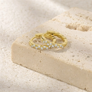Detailed view of gold S925 sterling silver hoop earrings with wavy design and cubic zirconia