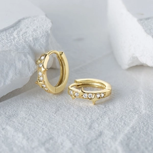 Detail of gold S925 silver star huggie earrings with sparkling cubic zirconia accents