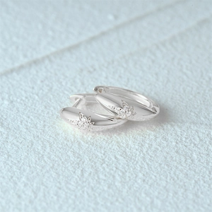 Detail shot of s925 silver hoop earrings featuring maple leaf charms with zircon inlay