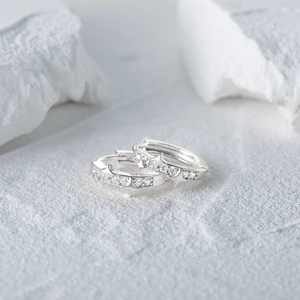 Macro shot of silver S925 sterling silver hoop earrings with star relief and crystals