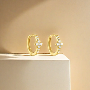 Detail of gold-plated hoop earrings with sparkling star-shaped zircon inlays