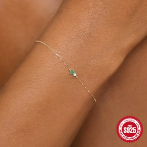Macro detail of S925 sterling silver chain bracelet with emerald and zircon stones