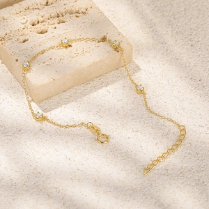Primer plano de pulsera de plata S925 dorada con cinco circonitas cúbicas engastadas