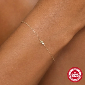 Macro detail of gold S925 sterling silver thin bracelet with dainty colorful gemstones