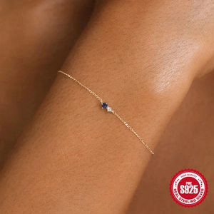 Detail of S925 sterling silver gold bracelet with navy blue and white round zircon stones