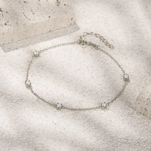 Detalle de una pulsera de plata de ley con cinco cristales brillantes engastados
