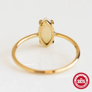Detail of s925 sterling silver ring with marquise-cut opal stone and gold finish