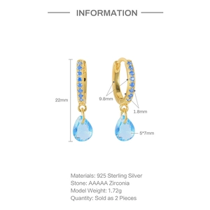 Detalle de pendientes de aro en plata S925 dorada con circonitas azules en forma de gota
