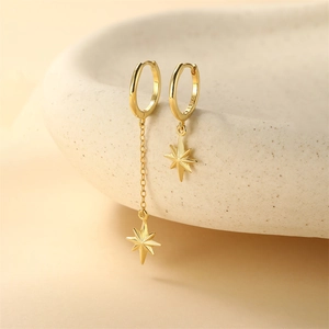Nahaufnahme der asymmetrischen S925 Sterlingsilber Sternohrringe mit Gold-Finish und Quasten