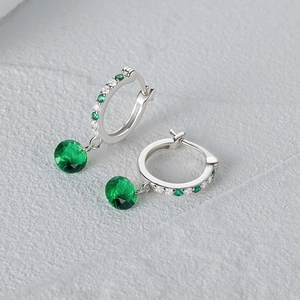 Detalle de pendientes de plata S925 con piedras verde esmeralda y pavé de circonitas finas