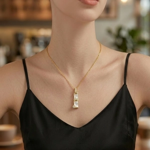Golden bamboo pendant necklace with white inlay worn by model for an elegant look