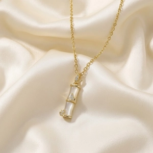 Elegant bamboo pendant necklace with white stone on champagne silk background