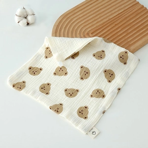 Close-up of a 100% cotton baby towel featuring cute brown cartoon bear patterns