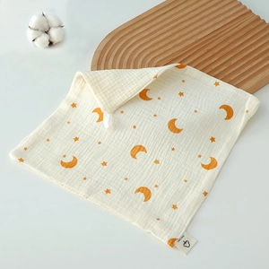 Detailed texture of cotton baby towel with yellow moon print and 100% cotton label