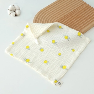 Macro view of soft 100% cotton gauze baby towel featuring fresh yellow lemon prints