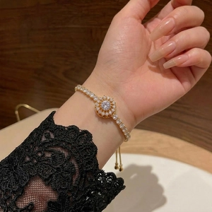 Elegant gold sunflower bracelet with zircon crystals worn on a woman wrist