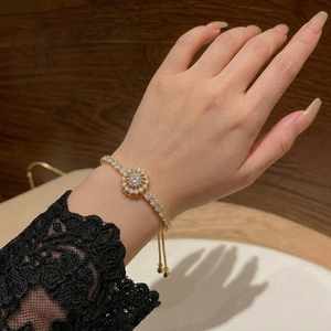 Elegant gold bracelet with spinning sunflower zircon charm and adjustable slider clasp
