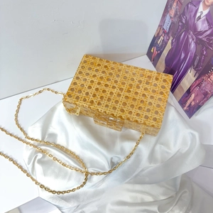 Retro yellow woven acrylic evening clutch bag with gold chain strap on silk fabric