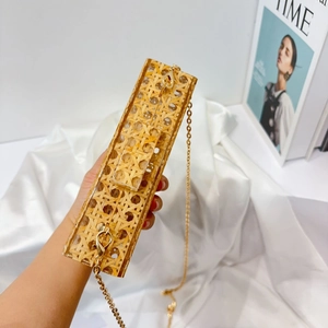 Detail of hand-woven rattan texture and clear acrylic frame with golden chain strap