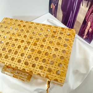 Close-up of vintage straw weave texture inside a clear acrylic evening clutch bag
