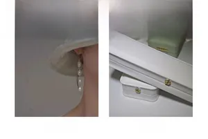 Close-up of elegant pearl drop earrings next to white and green luxury jewelry boxes