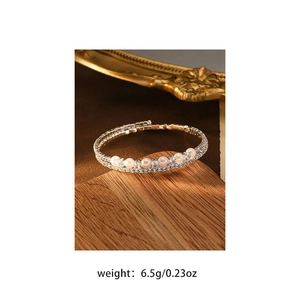 Detail showing multilayered silver bracelet with white pearls and sparkling cubic zirconia stones