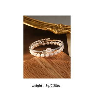 Detailed macro view of multilayer pearl bracelet with cubic zirconia on a wooden base