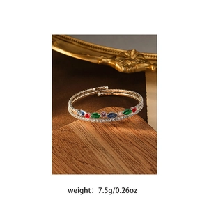 Detail of multilayer gold bracelet with colorful marquise-cut gems and micro-diamonds