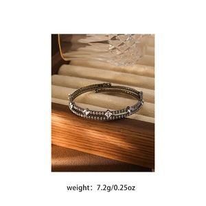 Macro shot of multi-layer silver bracelet with clear crystals in a beige velvet jewelry box