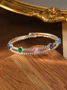Detailed macro view of multi-layer spiral bracelet with colorful zircons and pearls