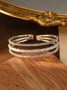 Macro view of a luxury triple-layered silver bracelet with white zircon and pearl inlay