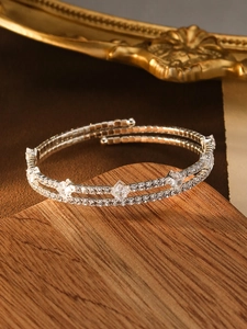 Detail of silver double-layer bracelet with white zircons on vintage wooden surface