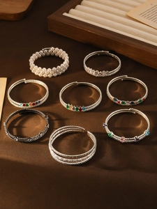 Detail of luxury pearl and colorful zircon bracelets on vintage wooden display