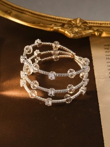 Macro shot of silver-tone triple-layer spiral bracelet with cubic zirconia and pearls