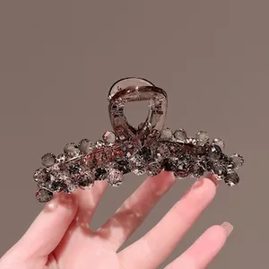 Detail of dark grey beaded hair claw clip with faceted gems and acrylic finish