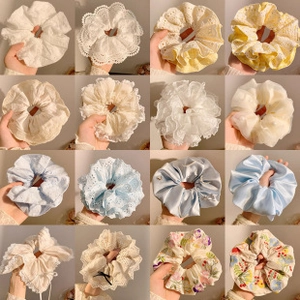 Macro shot of assorted colorful scrunchies with lace, satin, and floral embroidery details