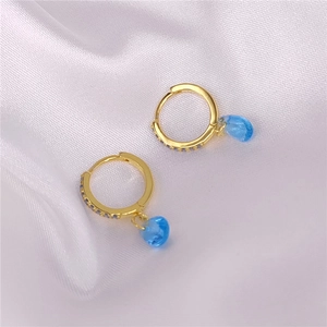 Detalle de los pendientes de aro en plata S925 bañados en oro con colgantes azules